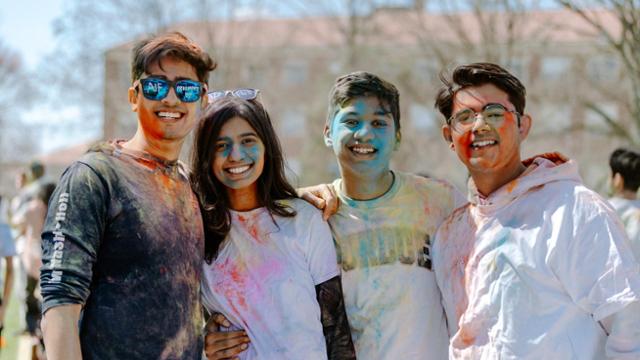 Students covered in colors at a Festival of Colors event.