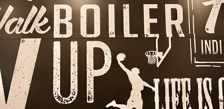 Signage that reads "Boiler Up" mixed in with several other words and phrases, such as "Life", "Pacers", and a silhouette of a basketball player going for a dunk.