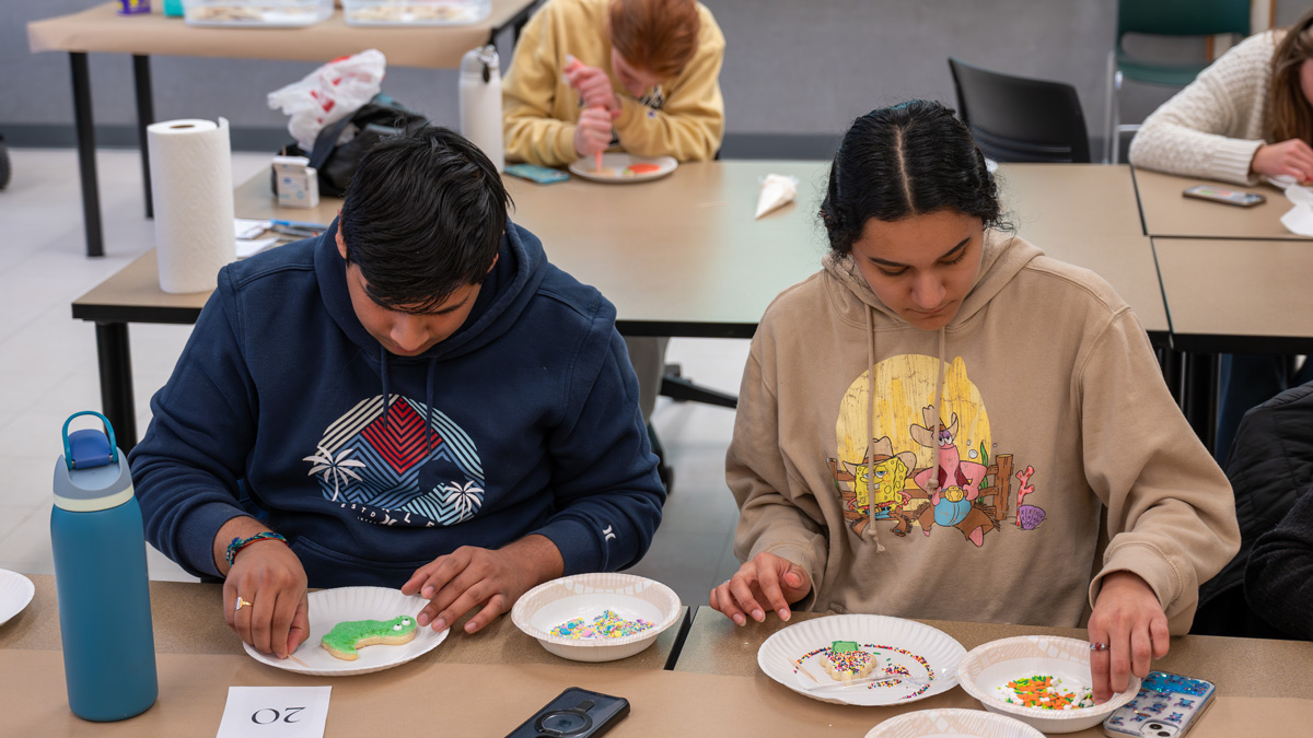 Two students decorating cookies.
