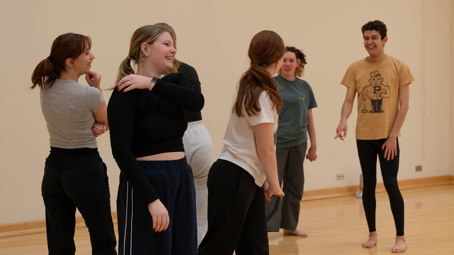 A group of PCDC dancers laughing together in studio