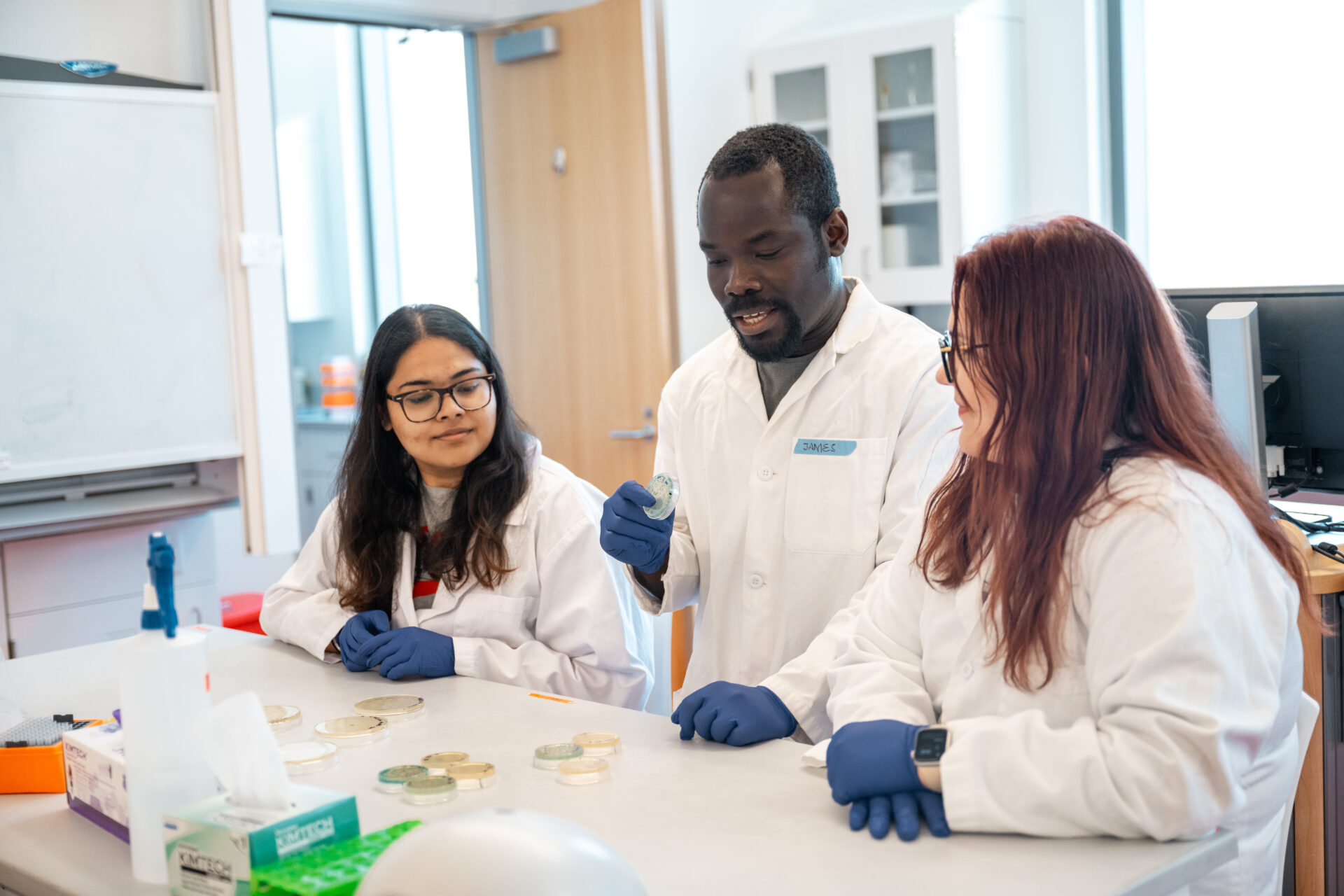 A small of team of lab coats working together on research.