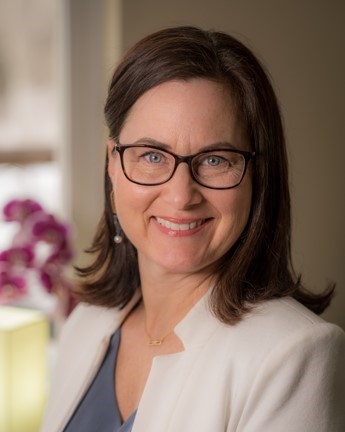 Professional headshot of a woman smiling confidently