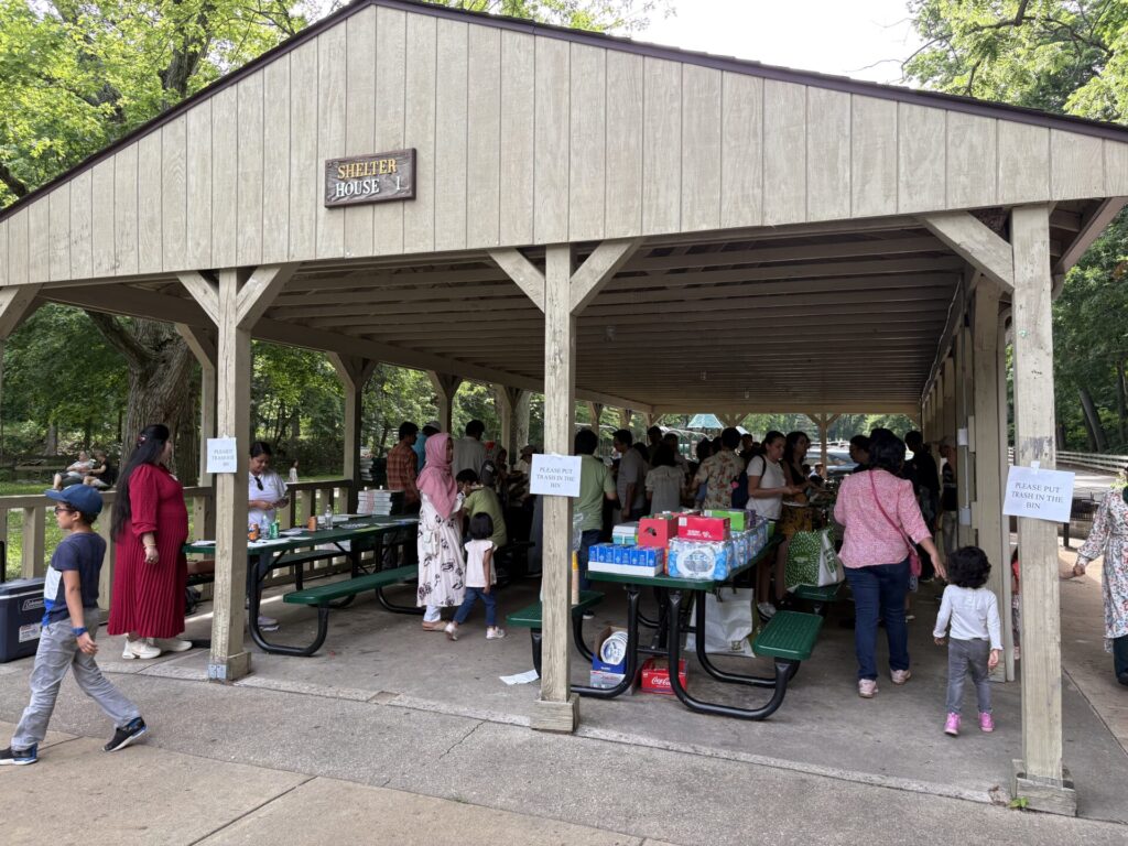 Postdocs gather to eat under a park shelter.
