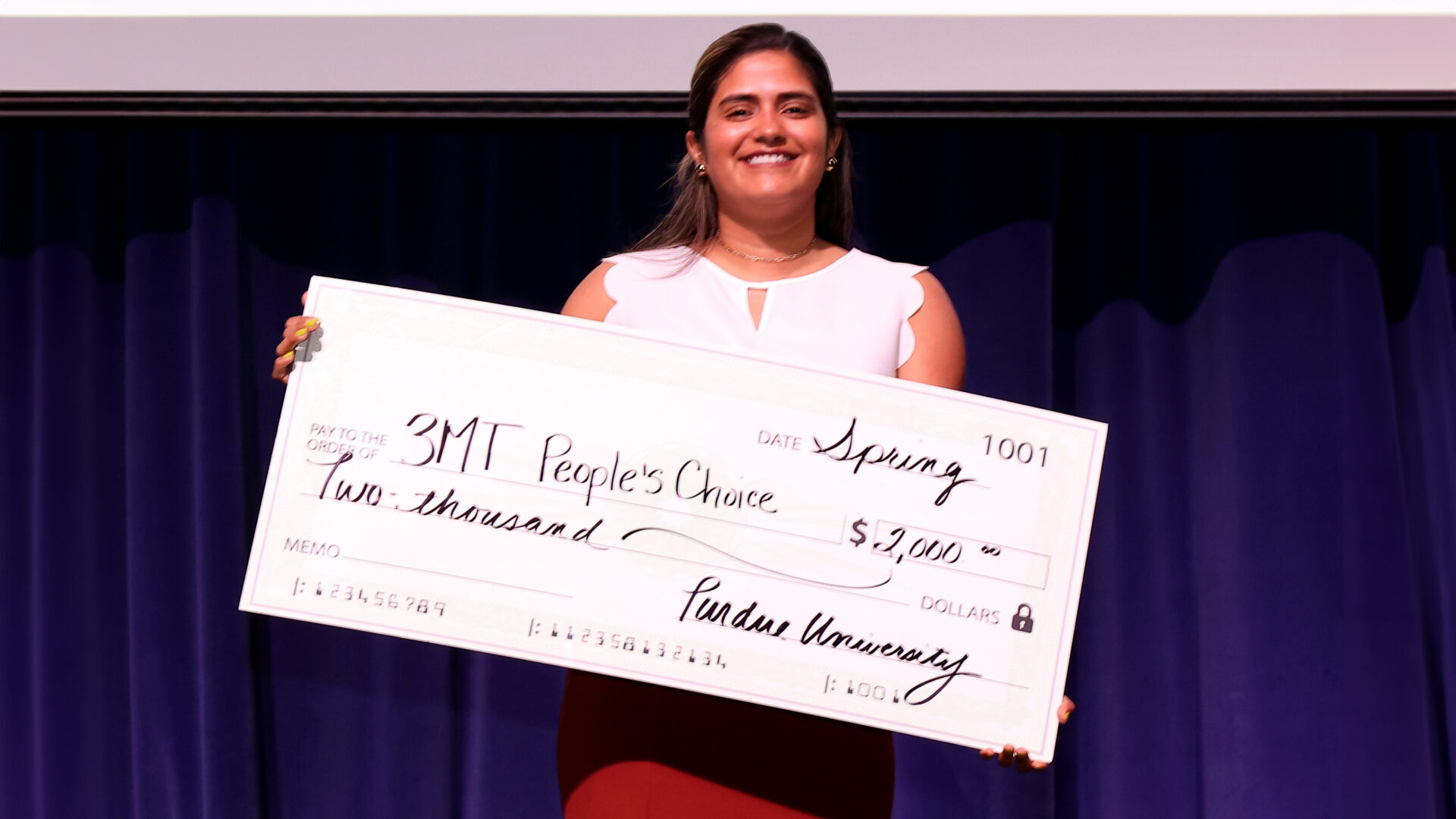 Woman holding a big check that says 