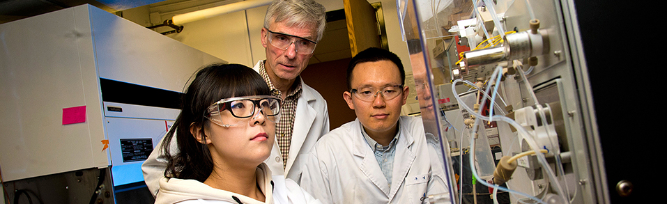 A student working in a lab with two instructors