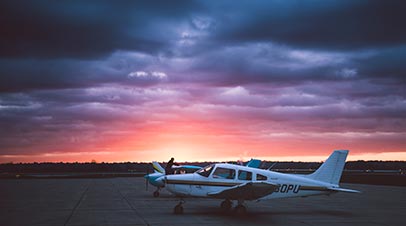 Airplane at the Purdue University airport with cloudy sunset/sunrise in the background.