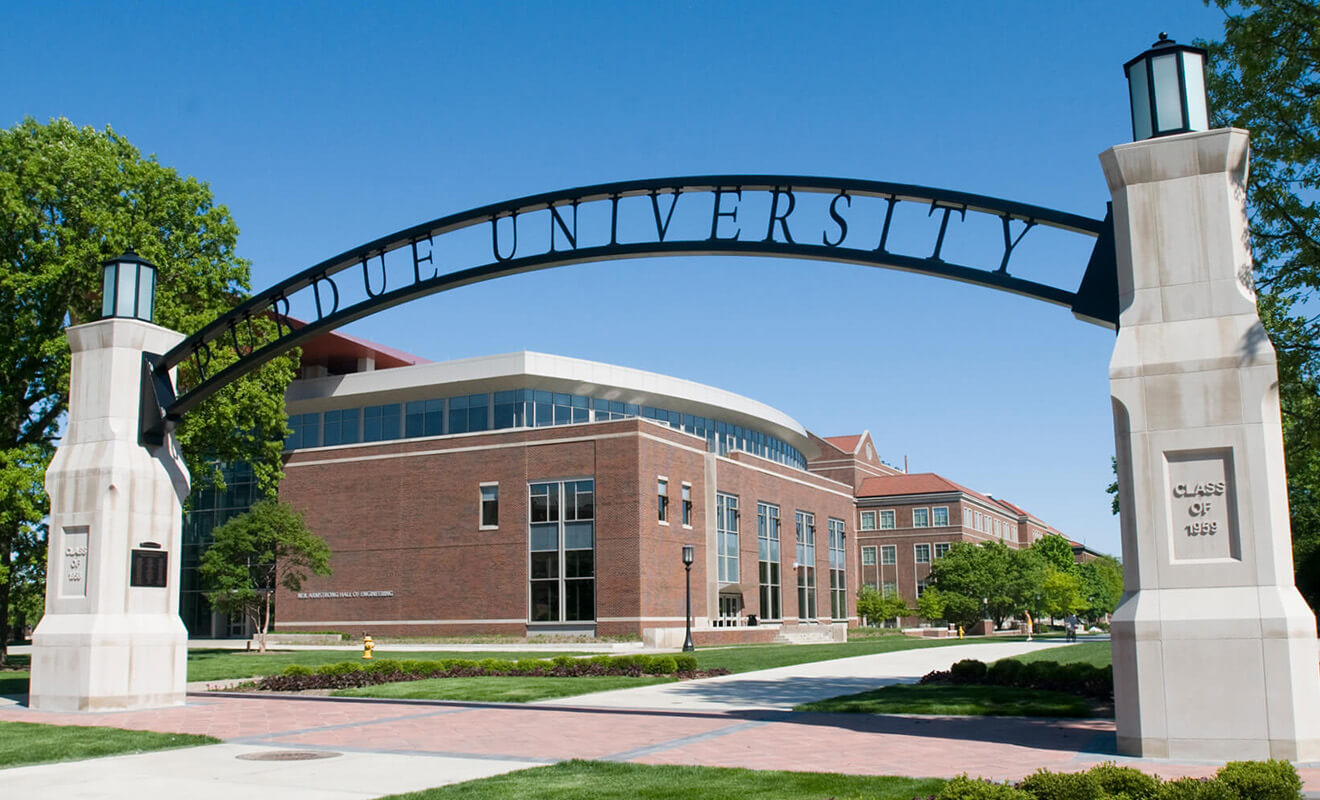 The Purdue University gateway arch standing in front of a brick campus building
