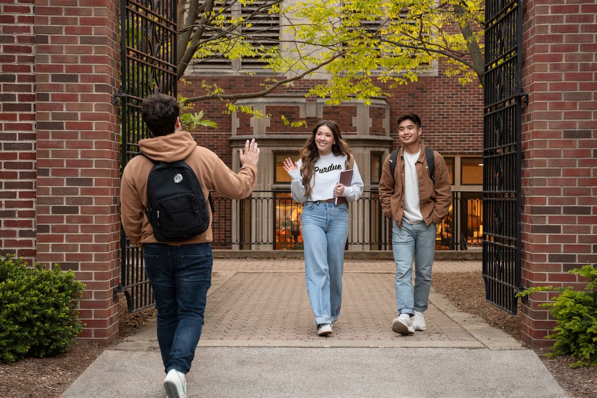 Purdue students waving hello on campus