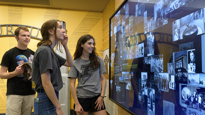 Purdue students looking at a large digital display.