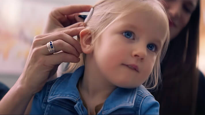 Young girl receiving a hearing aid