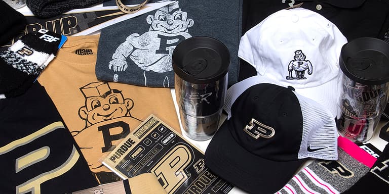 Assorted Purdue University merchandise including hats, shirts, and tumblers.