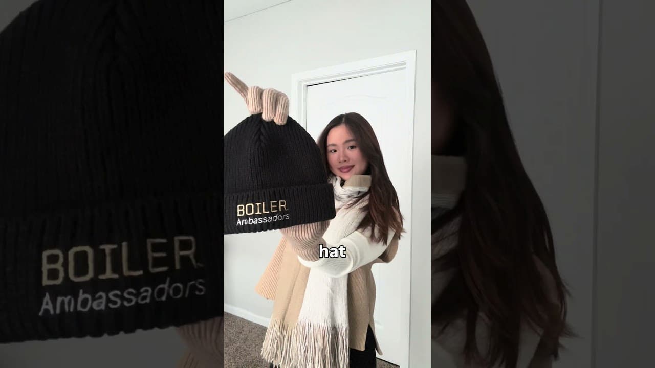 Woman holding a Boiler Ambassadors beanie hat.