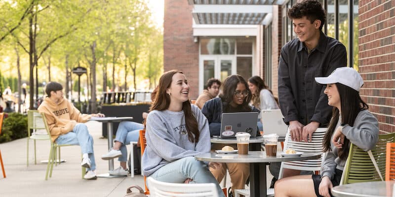 Purdue students socializing at an outdoor campus patio