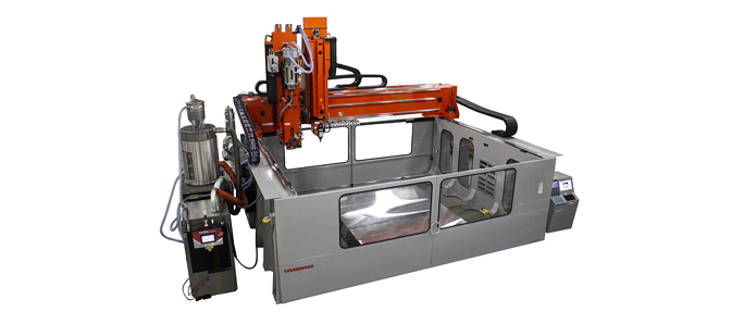 Enclosed CNC machining system with an orange gantry-mounted cutting head operating over a flat work surface, surrounded by a protective metal housing with viewing windows and integrated controls.
