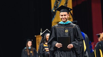 Male graduate accepting his diploma on stage during commencement