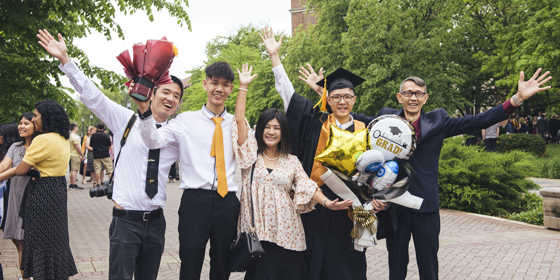 Family and their graduate celebrating with raised arms