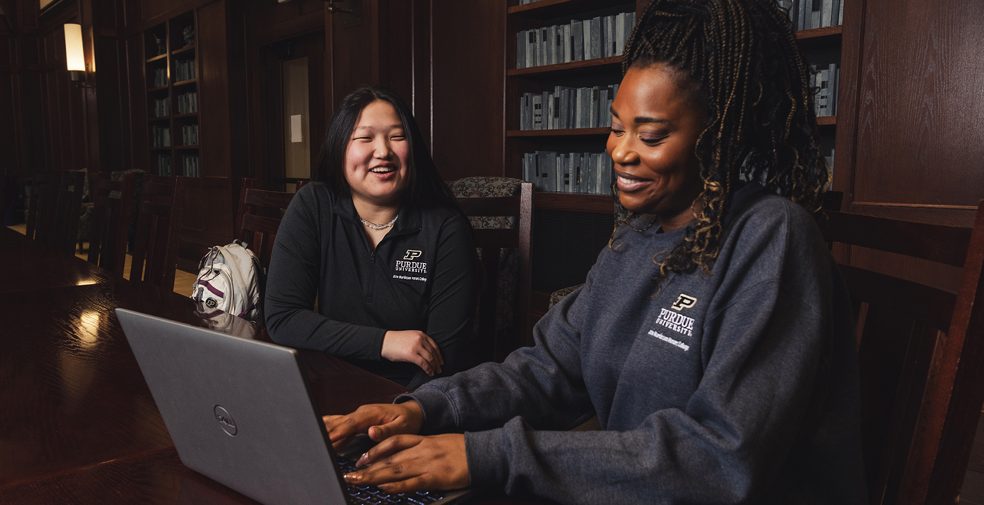 Academic advisors meeting with students and a laptop