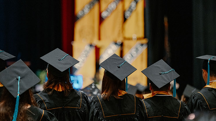 Graduates facing the stage during graduation ceremony