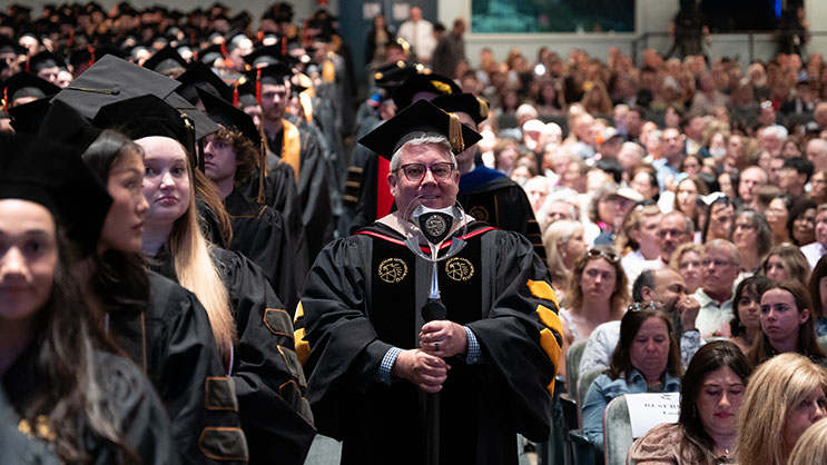 A Purdue official carrying the ceremonial mace, leading the procession at graduation inside Elliott Hall of Music.  