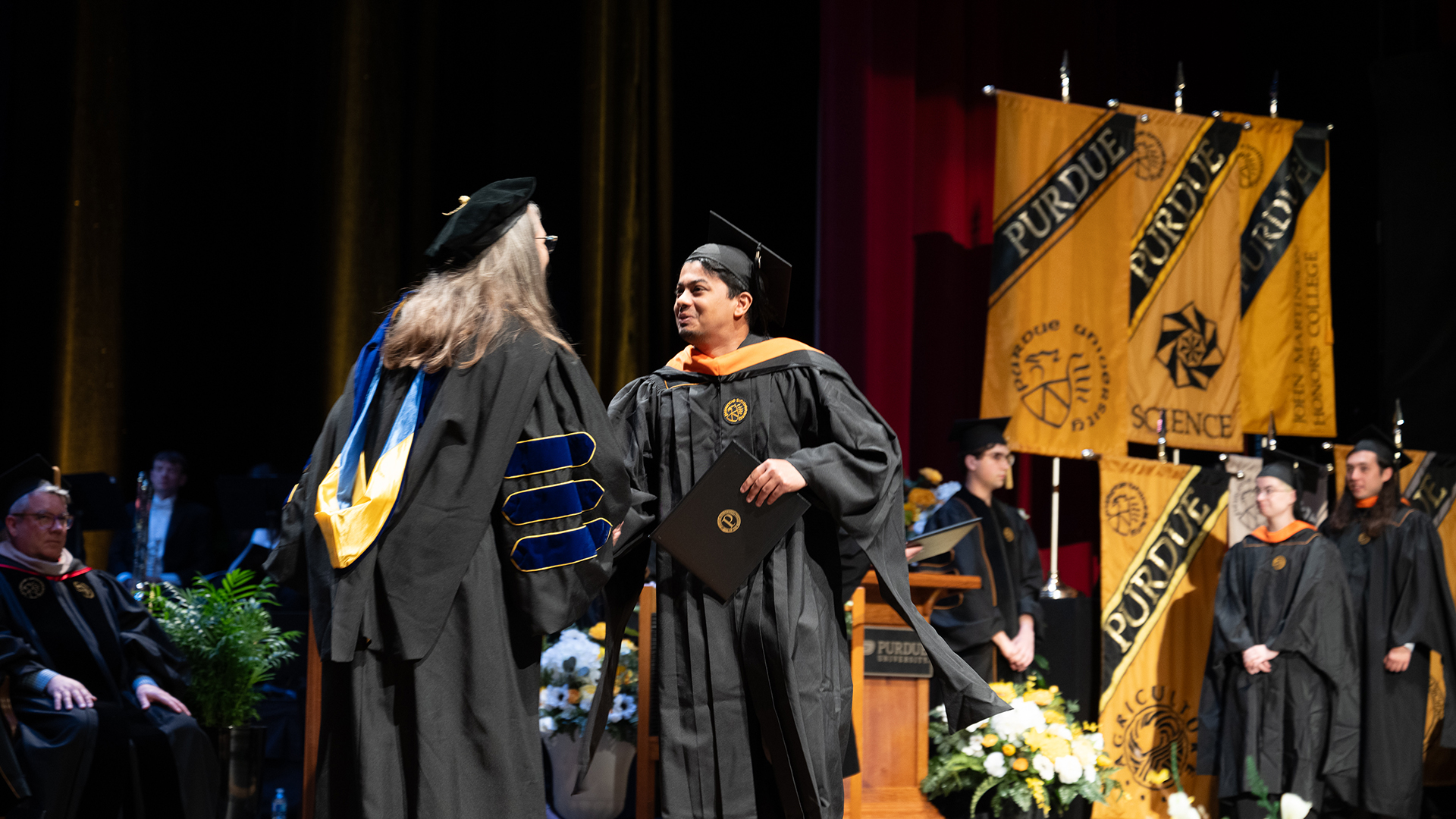 Graduate on stage accepting diploma