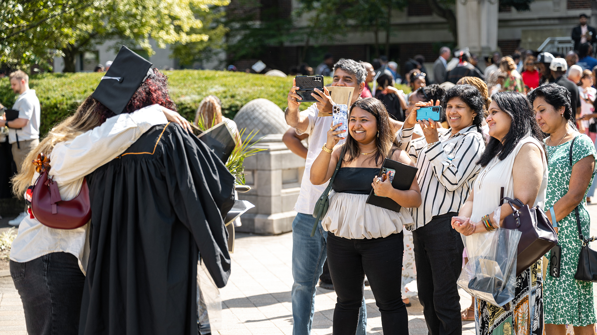 Families taking pictures of grads outside on the day of commencement