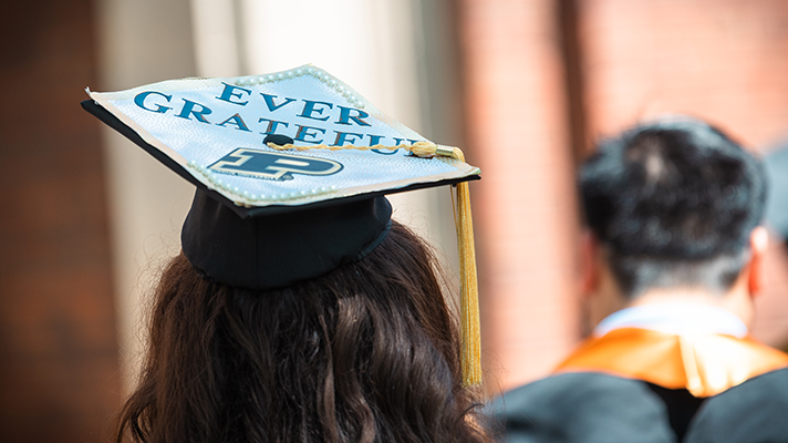 The back of a Purdue graduate with ever grateful on the top of their mortar board