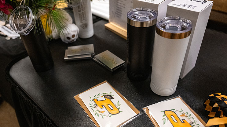Close up of table with assorted Purdue graduation gifts; tumbler, cards