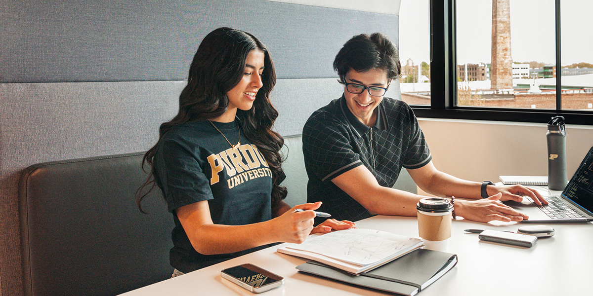 Two students study together in a booth