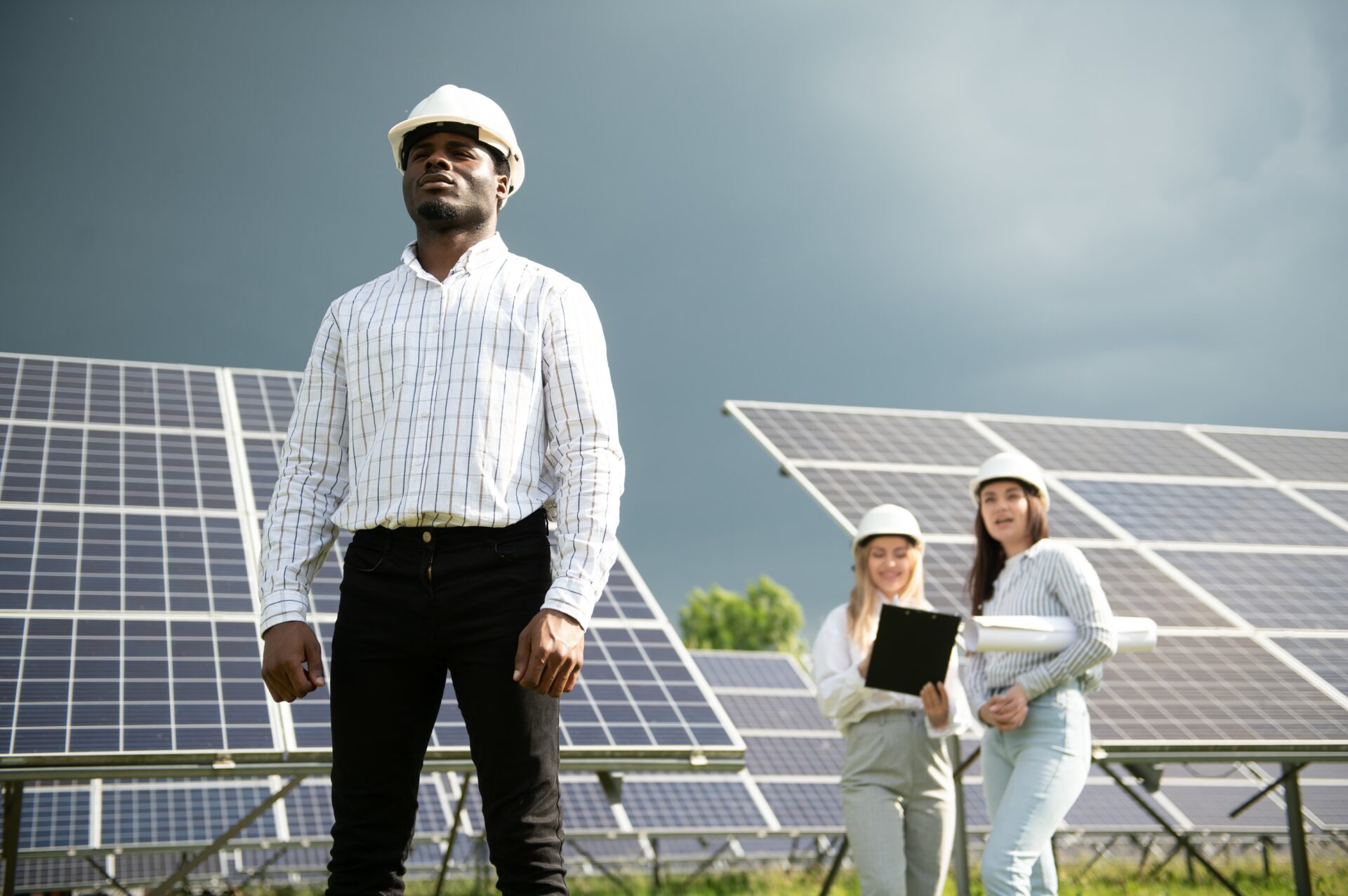 Male and female engineers worker working in solar panels power farm. technician working at solar power station.