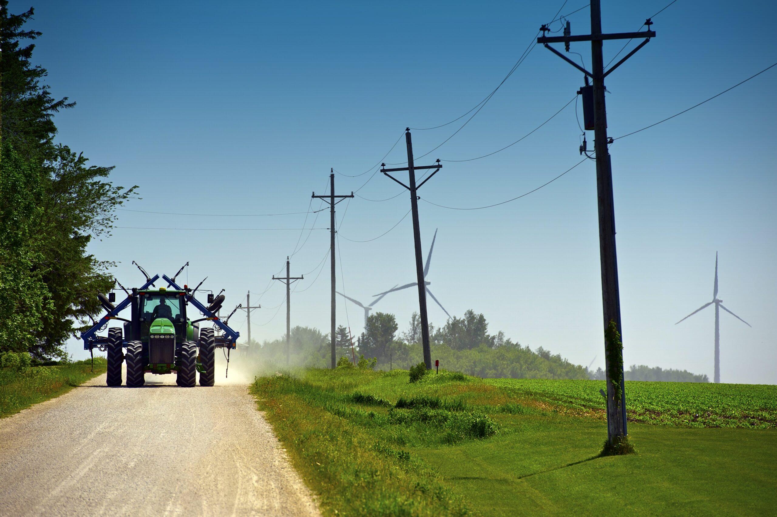 Farm tractor and implement on gravel country road