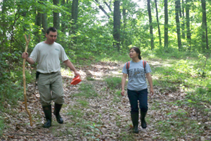 Dr. Jeff Holland walking in forest with research team