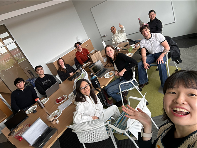 A selfie of the lab group members celebrating a birthday.