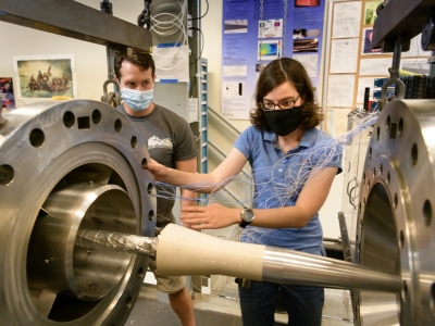 Two people working with a specimen in the wind tunnel
