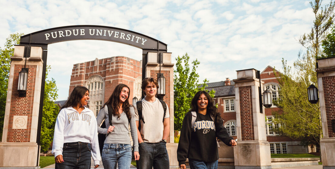 students walking around Purdue's West Lafayette campus with the Purdue University archway in the background