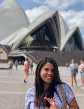 Maria Ramirez smiles with Sydney Opera House and pedestrians in the background