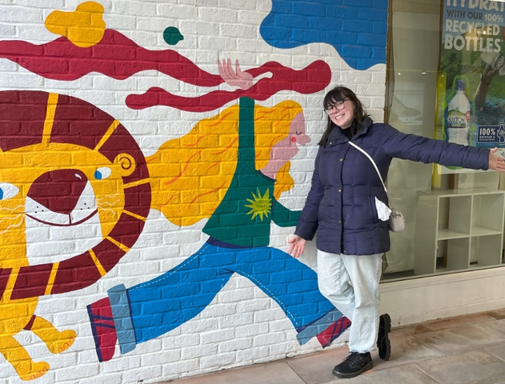 Addie Waltz in front a painted mural on a wall