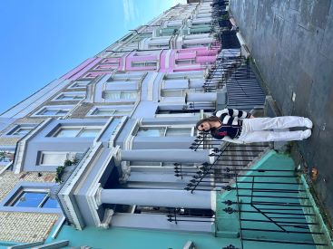 Ana Isabel Gonzalez poses in front of pastel colored row houses in London