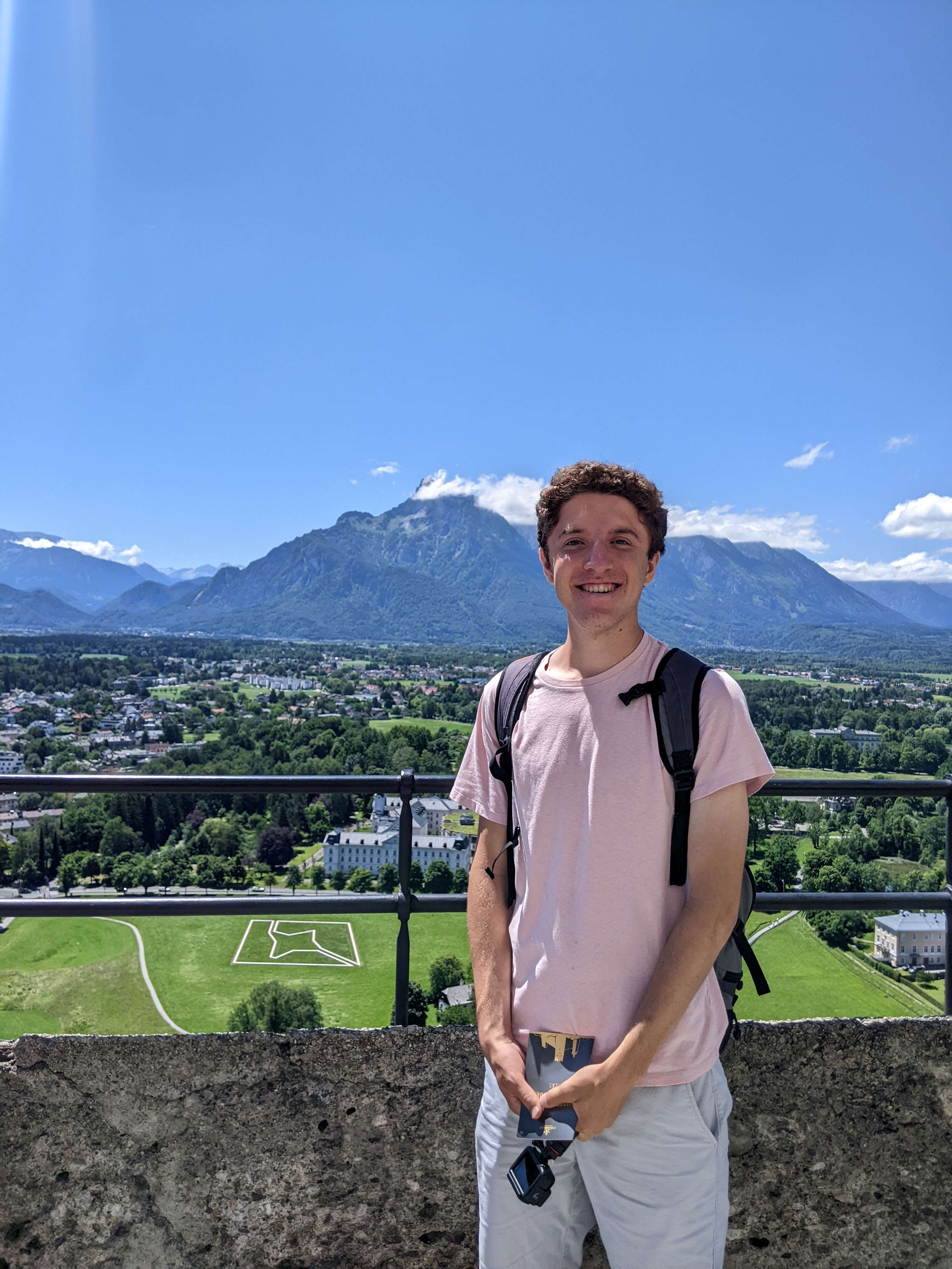Josh Keagle poses on a sunny day with a city backdrop