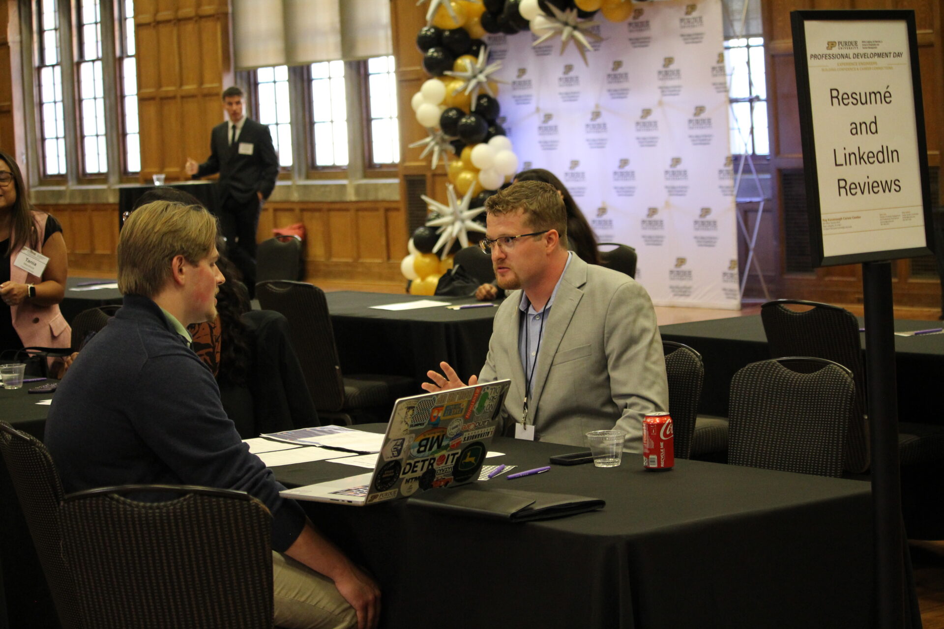 Two millennial women female friends sitting outdoors eating takeaway food, laughing and having fun. Food delivery and takeout.