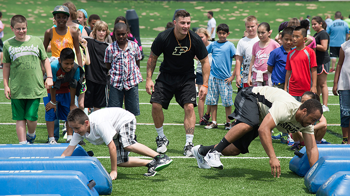 Purdue Football player B.J. Knauf, wide receiver, puts participants through their paces with a bag relay race.