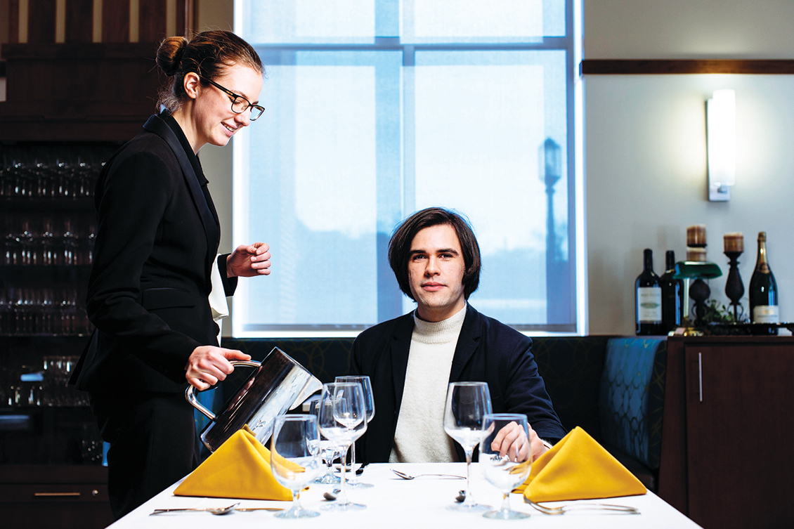 Illusionist Scott Silven sits at a table in the John Purdue Room as Magdolene DeVoe (HTM ’16) fills his water glass.