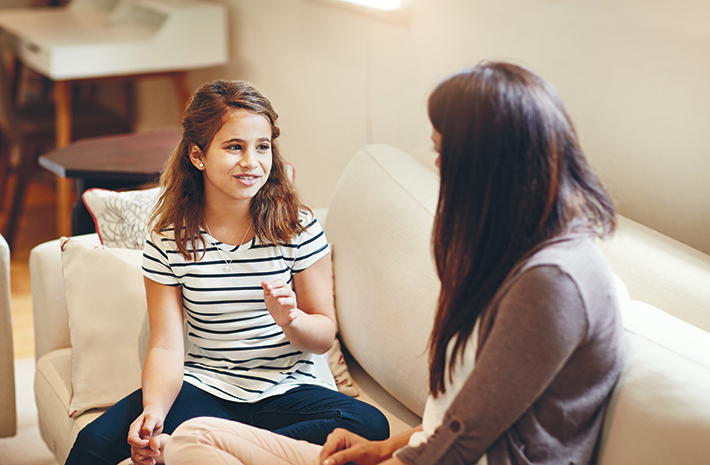 Young girl sits with mom