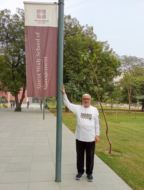 Ramadhar Singh stands next to Ahmedabad University Amrut Mody School of Management sign.