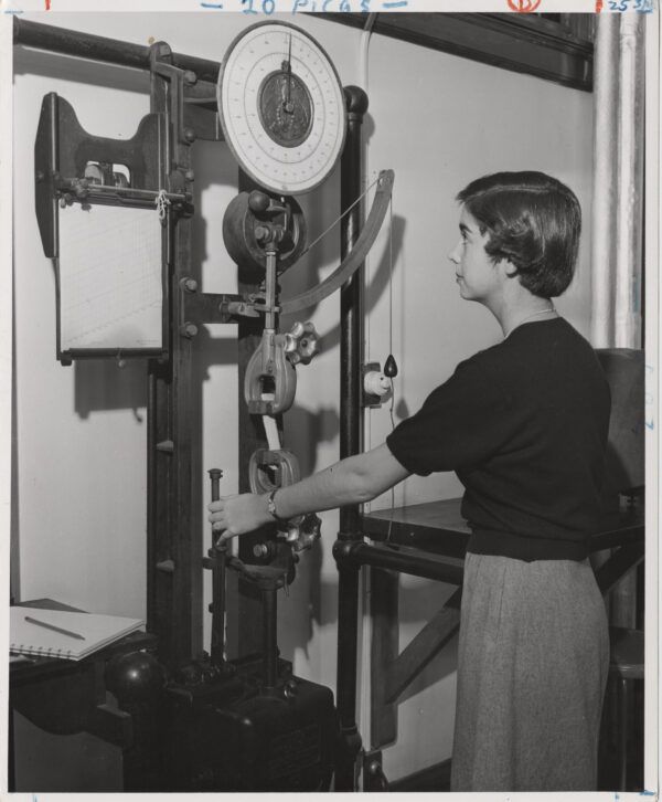 A home economics student works in the textile lab on the breaking strength machine