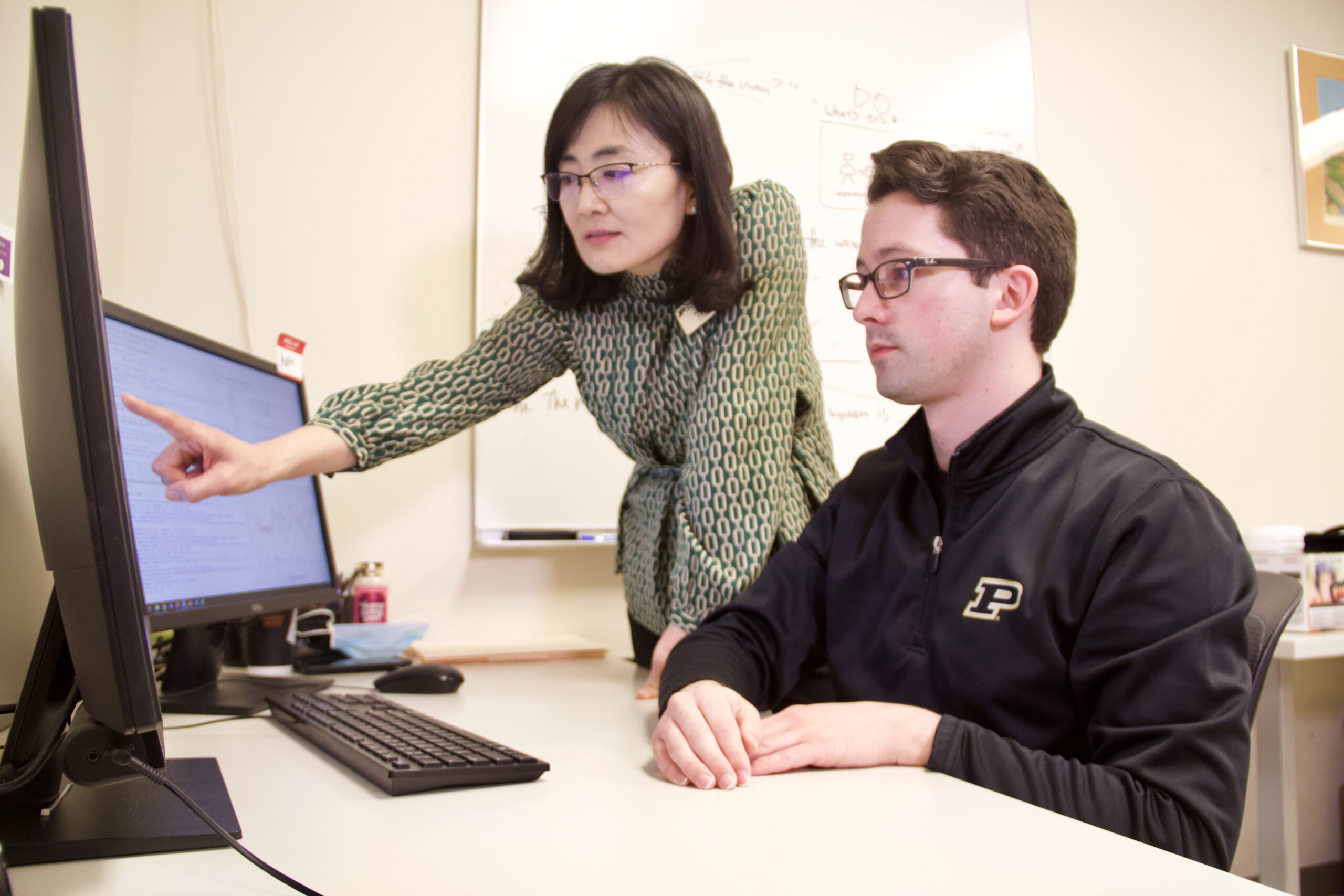 Jiyeon Lee and her master's student Austin Keen look at data collected from a recent experiment.