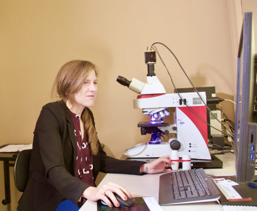 Professor Sydney Trask sits at her digital microscope.