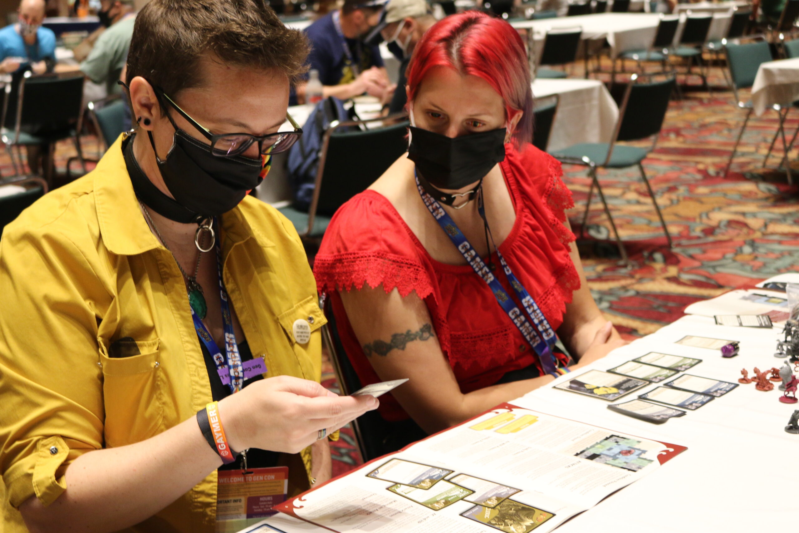 Gen Con attendees sit and play a tabletop card game