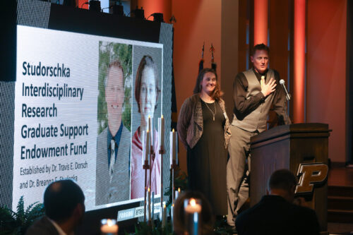 Travis Dorsch and his wife, Breanna Studenka, address the audience at the Center for Families gala