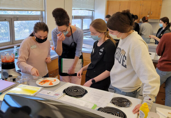 Students look at food consistency under the guidance of a faculty member