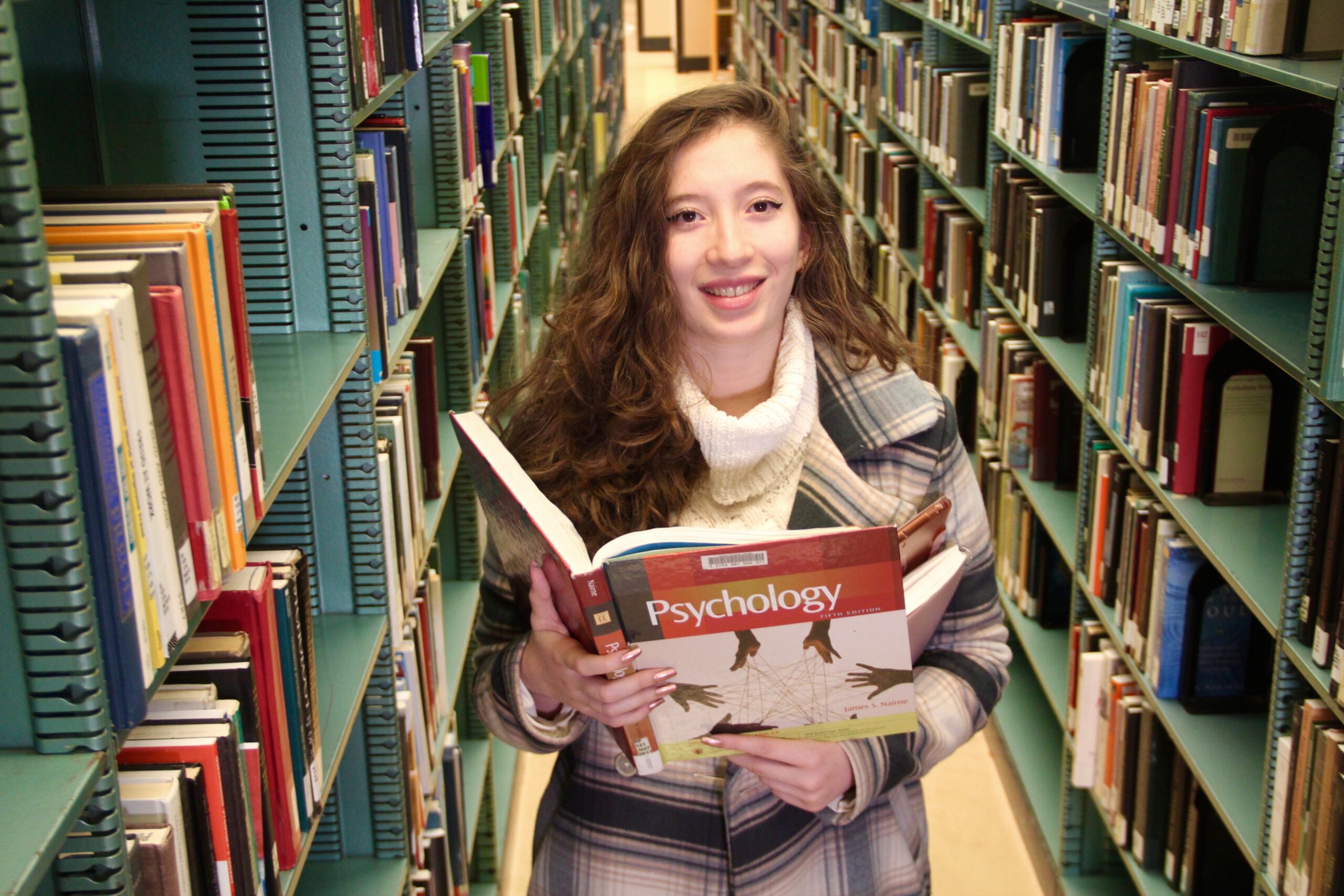 Paulina Tangassi Lucio holds a book while posing for a photo.